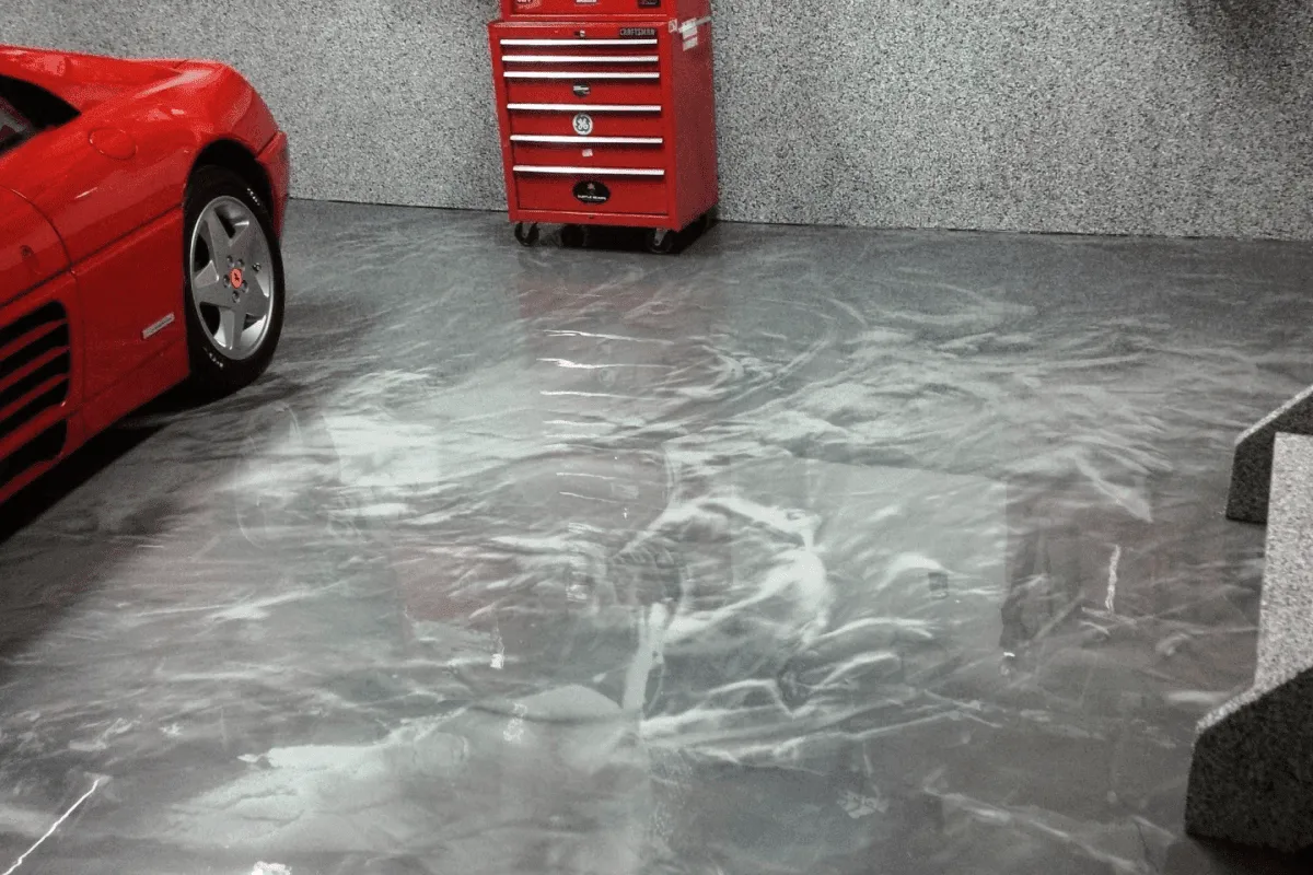 A red car parked in a garage next to a red toolbox