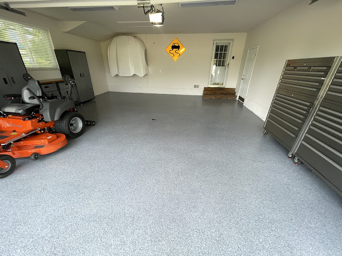 A garage with a lawn mower and other equipment