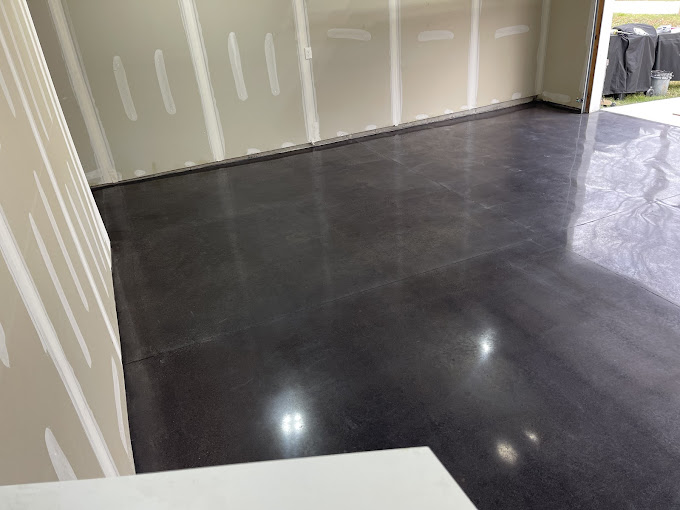 A room with a white wall and a black floor