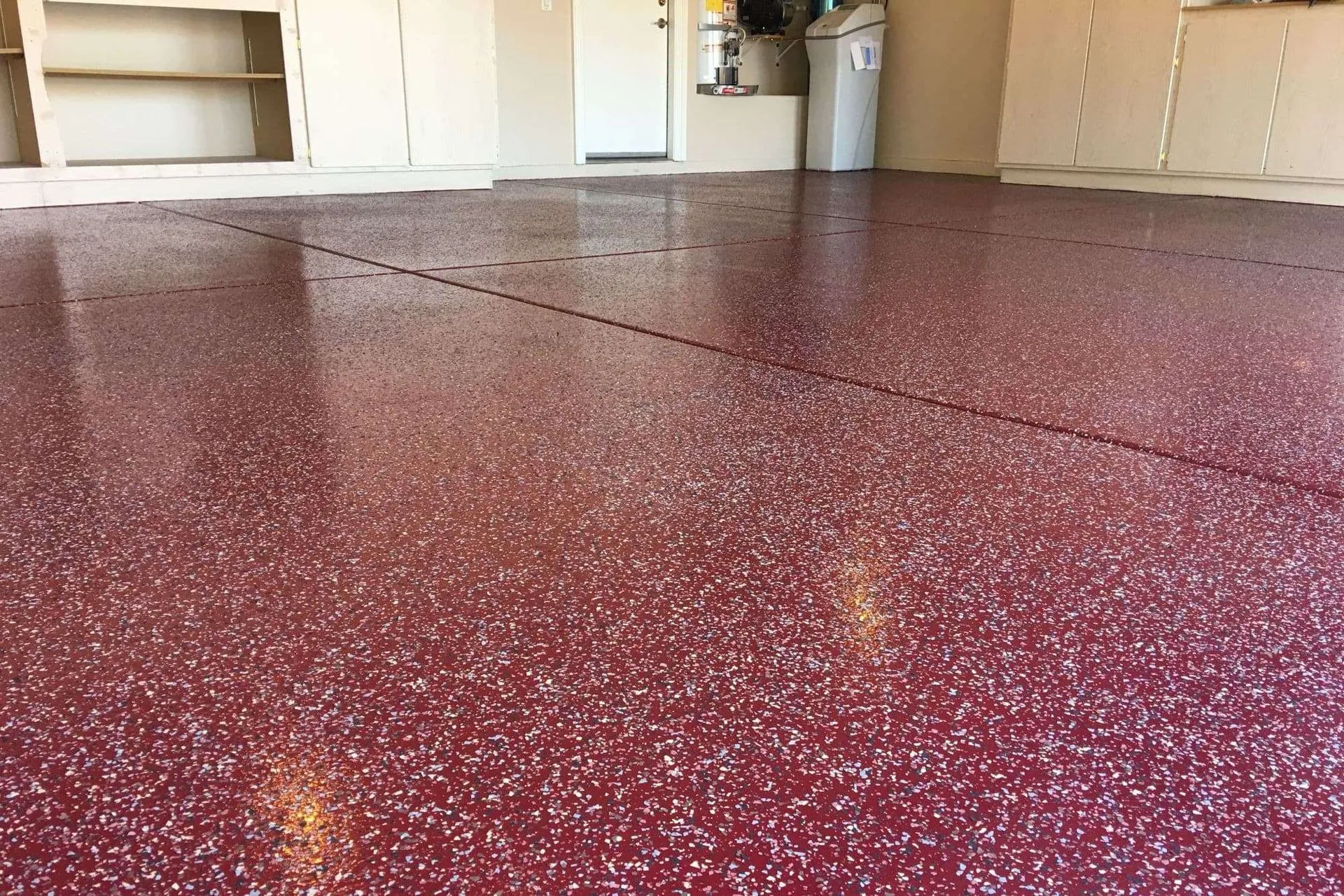 A room with a red floor and cabinets